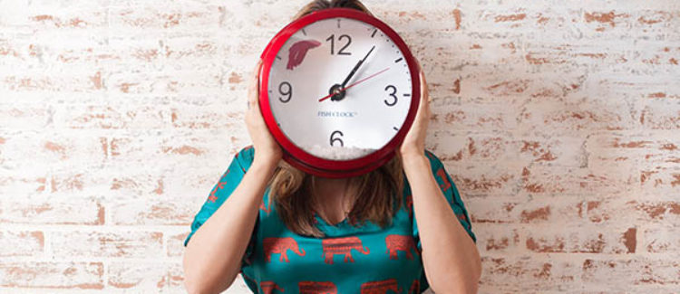 Woman Holding Clock Over Face